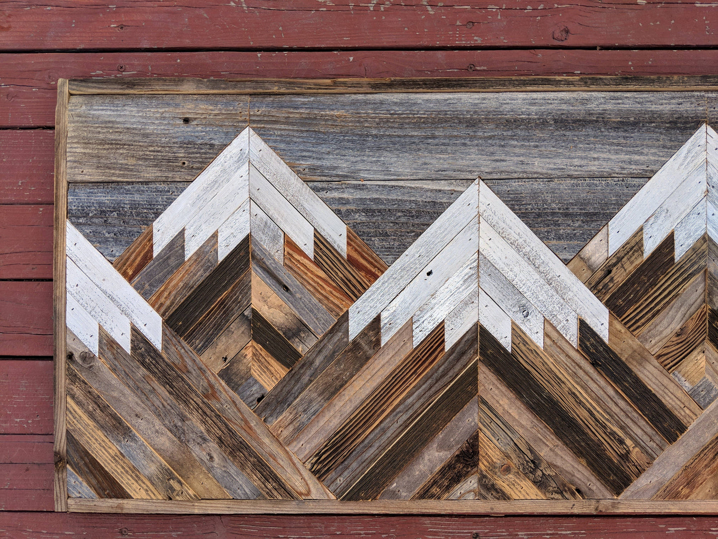 Rustic mountain wood wall art with gray sky.